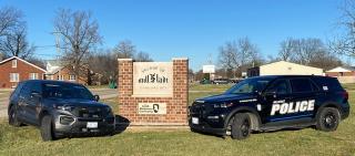 Picture of two Millstadt Police Cars in front of Welcome Sign